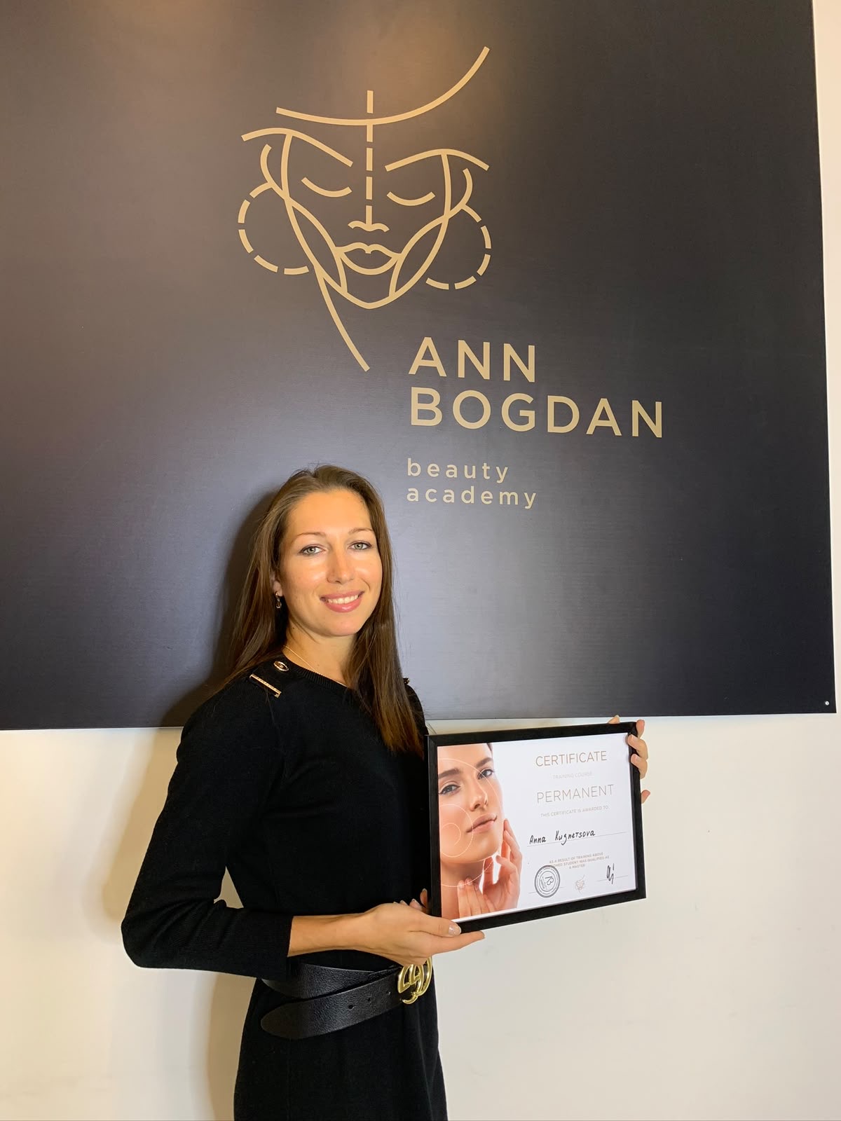 Anna holding her Ann Bogdan Beauty Academy certificate